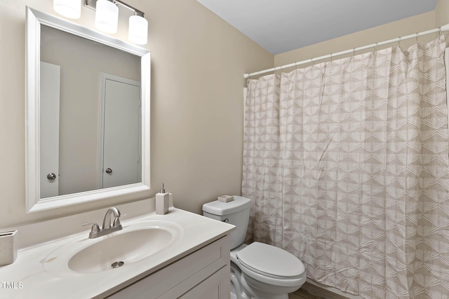 bathroom featuring vanity, toilet, and curtained shower