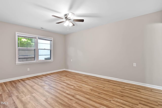 unfurnished room featuring a ceiling fan, light wood-style flooring, and baseboards