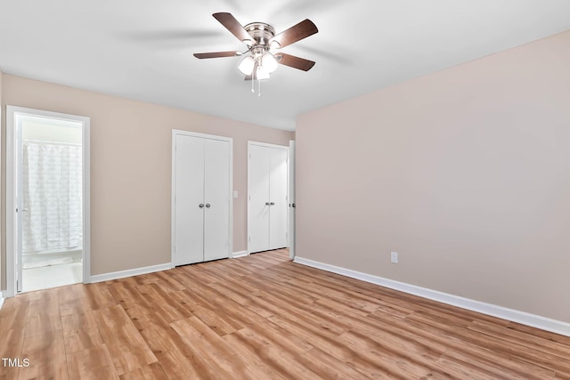 unfurnished bedroom featuring baseboards, light wood-style floors, and ensuite bath