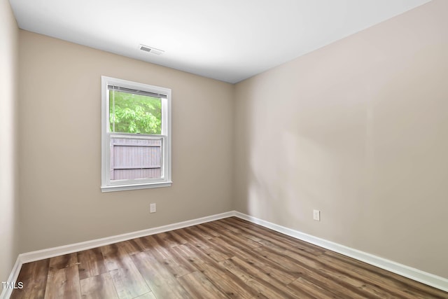 empty room featuring wood finished floors and baseboards