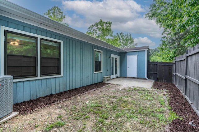 rear view of house with a fenced backyard, cooling unit, and a patio area