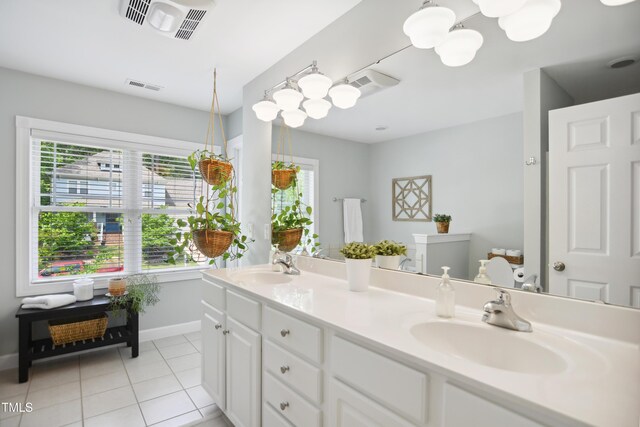 full bathroom with tile patterned flooring, baseboards, double vanity, and a chandelier