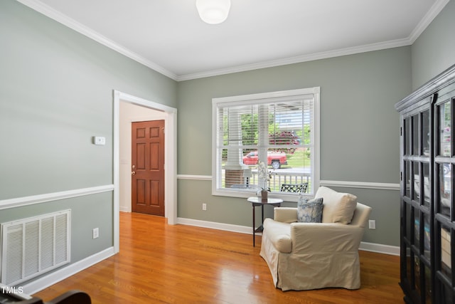 living area featuring ornamental molding, wood finished floors, and baseboards