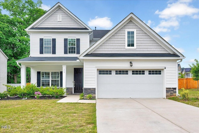view of front of house featuring concrete driveway, stone siding, and covered porch