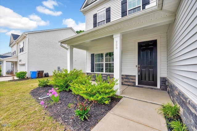 property entrance with a porch and stone siding