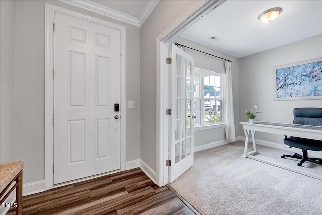 foyer entrance featuring baseboards, crown molding, and wood finished floors