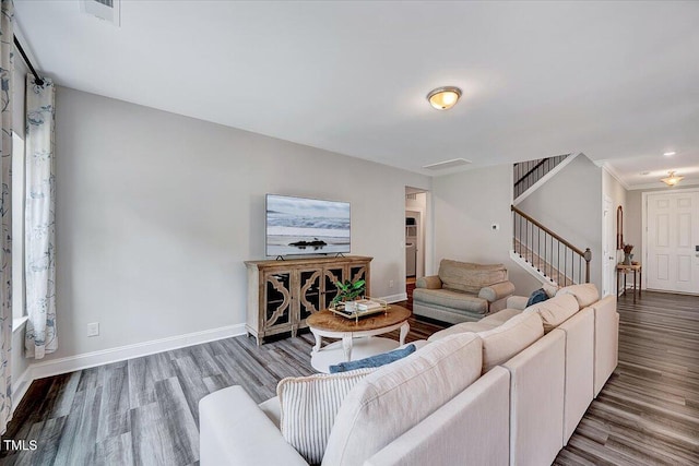 living room featuring stairway, wood finished floors, and baseboards