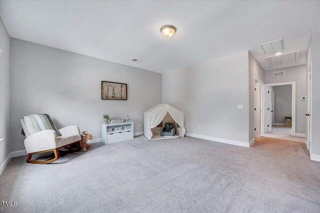 living area with attic access, carpet, and baseboards