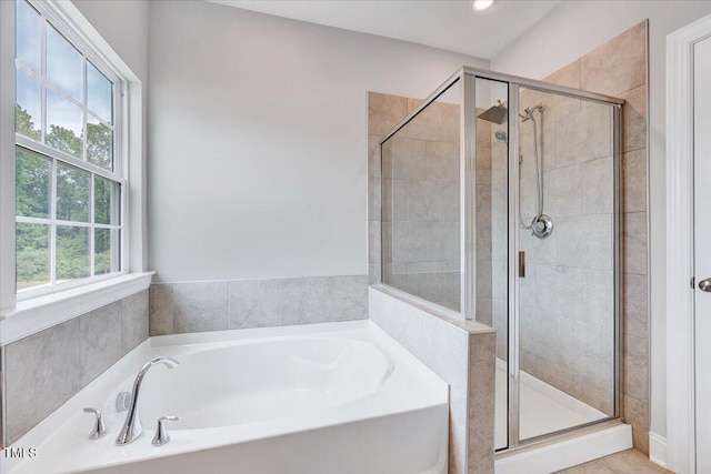 full bathroom with a shower stall and a bath