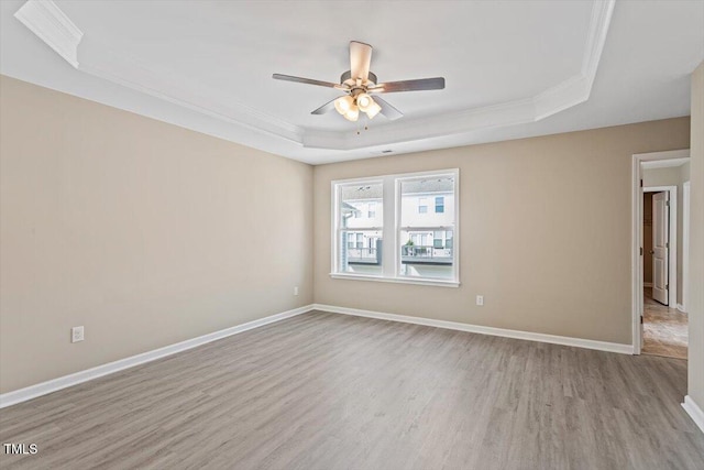 1027 Myers Point Dr, Morrisville, NC 27560 - empty room featuring a raised ceiling, wood finished floors, ceiling fan, ornamental molding, and baseboards