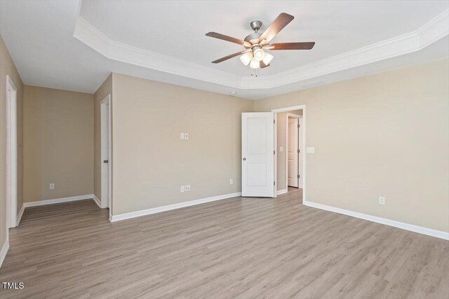 1027 Myers Point Dr, Morrisville, NC 27560 - spare room featuring a raised ceiling, light wood-type flooring, a ceiling fan, baseboards, and ornamental molding