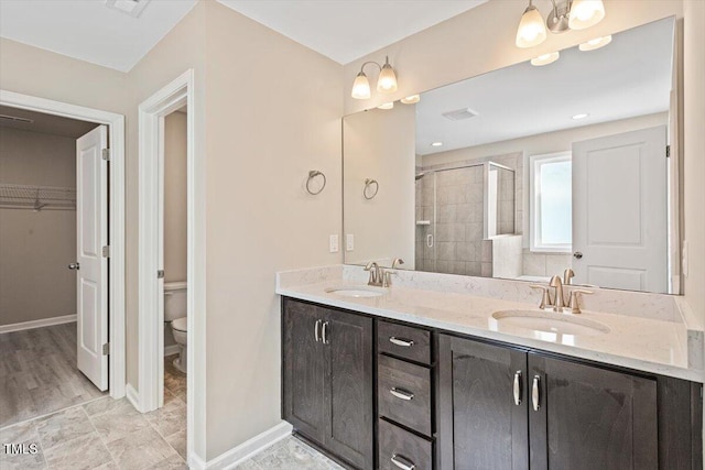 1027 Myers Point Dr, Morrisville, NC 27560 - bathroom with a stall shower, toilet, double vanity, a spacious closet, and baseboards