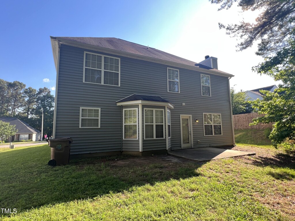 back of house featuring a chimney and a patio area