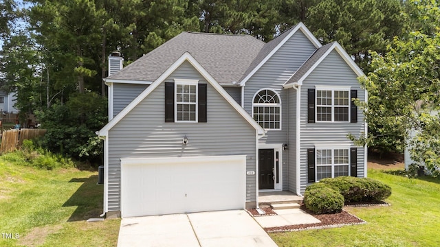 204 Trevor Ridge Dr, Holly Springs, NC 27540 - traditional-style home featuring a front yard, driveway, a chimney, and a shingled roof