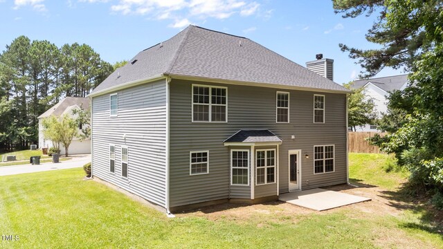 204 Trevor Ridge Dr, Holly Springs, NC 27540 - back of house with a chimney, roof with shingles, and a patio area