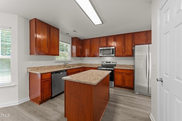 204 Trevor Ridge Dr, Holly Springs, NC 27540 - kitchen with appliances with stainless steel finishes, light wood finished floors, and a center island
