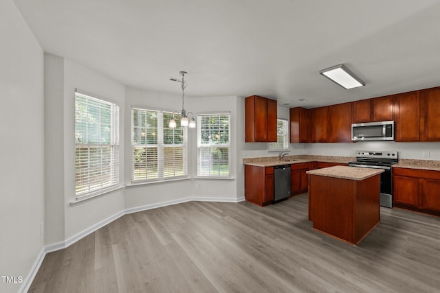 204 Trevor Ridge Dr, Holly Springs, NC 27540 - kitchen with appliances with stainless steel finishes, wood finished floors, healthy amount of natural light, and a chandelier