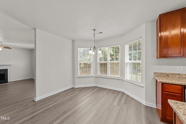 204 Trevor Ridge Dr, Holly Springs, NC 27540 - unfurnished dining area with light wood-style flooring, a chandelier, ceiling fan, and a fireplace