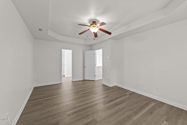 204 Trevor Ridge Dr, Holly Springs, NC 27540 - empty room with a raised ceiling, a ceiling fan, and dark wood-type flooring