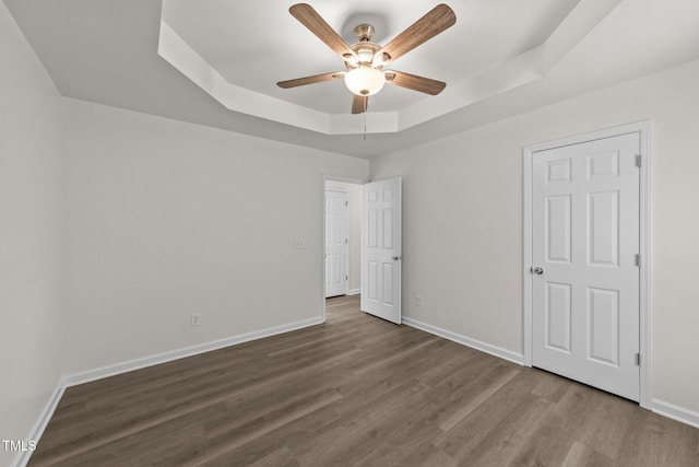 204 Trevor Ridge Dr, Holly Springs, NC 27540 - unfurnished bedroom with a tray ceiling, wood finished floors, and a ceiling fan