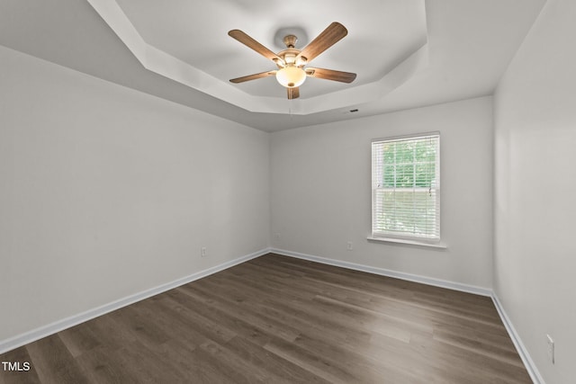 204 Trevor Ridge Dr, Holly Springs, NC 27540 - spare room featuring a tray ceiling, ceiling fan, and dark wood-style floors