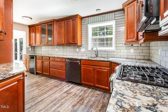 105 Hiddenwood Ct, Garner, NC 27529 - kitchen with appliances with stainless steel finishes, a sink, light wood-style floors, and decorative backsplash