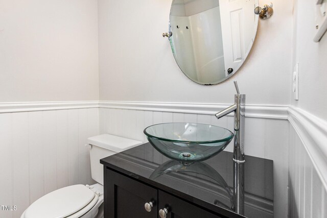 105 Hiddenwood Ct, Garner, NC 27529 - bathroom featuring a wainscoted wall, vanity, toilet, and a decorative wall