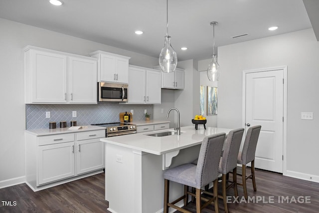 1412 Main St, Lillington, NC 27546 - kitchen with appliances with stainless steel finishes, a sink, dark wood-type flooring, tasteful backsplash, and recessed lighting
