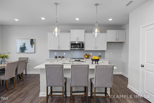 1412 Main St, Lillington, NC 27546 - kitchen featuring stainless steel microwave, light countertops, decorative backsplash, baseboards, and recessed lighting