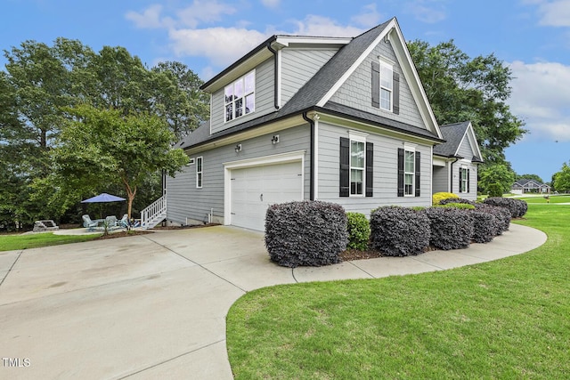 view of side of property with an attached garage, a yard, driveway, and a shingled roof
