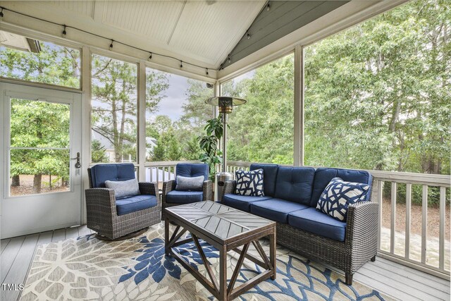sunroom / solarium featuring an outdoor hangout area and lofted ceiling
