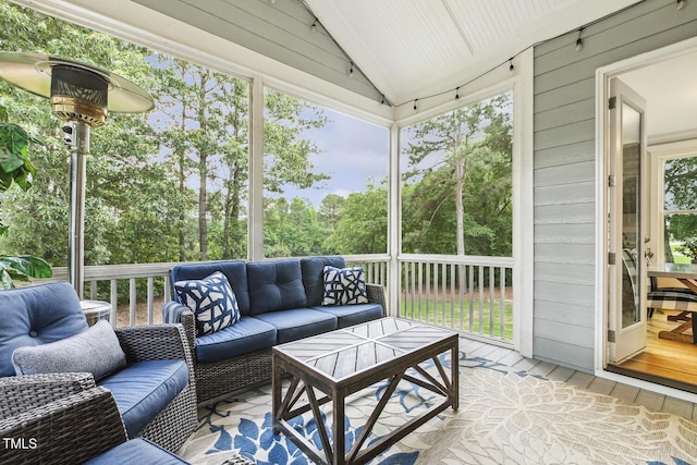 sunroom featuring outdoor lounge area and vaulted ceiling