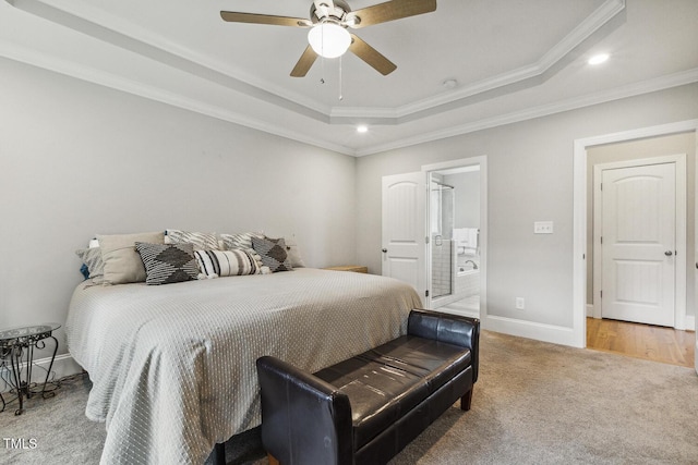 carpeted bedroom featuring a raised ceiling, crown molding, recessed lighting, baseboards, and ensuite bath