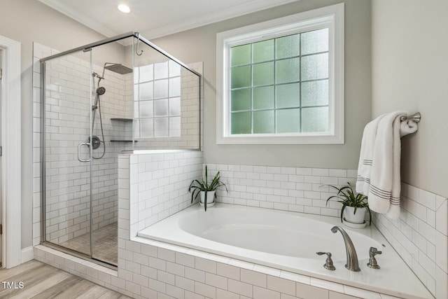full bath with a stall shower, a bath, plenty of natural light, ornamental molding, and wood finished floors