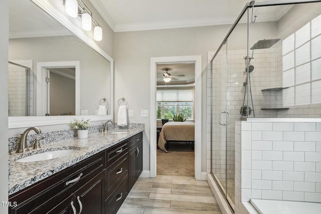 full bathroom with wood finished floors, a stall shower, a ceiling fan, double vanity, and ensuite bath