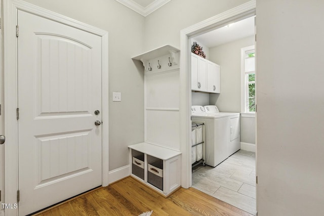 laundry room with washing machine and dryer, crown molding, cabinet space, baseboards, and light wood finished floors
