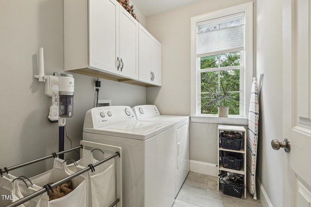 laundry room featuring cabinet space, separate washer and dryer, baseboards, and light wood-style floors