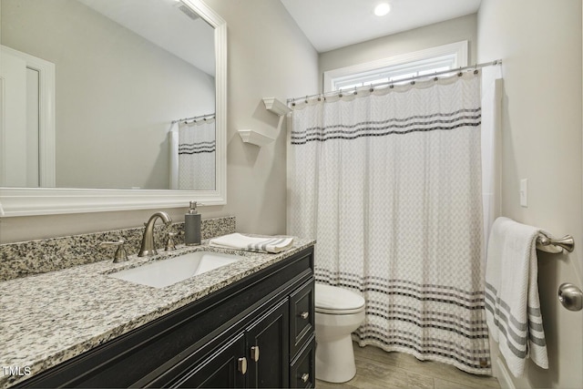 bathroom featuring wood finished floors, toilet, vanity, and a shower with shower curtain