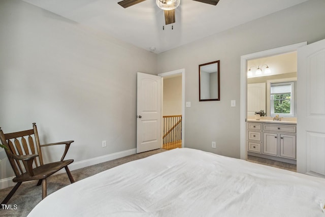 carpeted bedroom featuring baseboards and connected bathroom