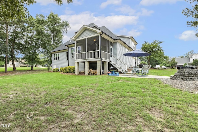 back of property featuring a sunroom, stairway, a patio area, a ceiling fan, and a yard