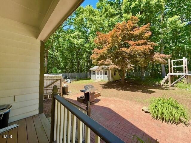 view of patio / terrace with an outbuilding, a fenced backyard, and a storage unit