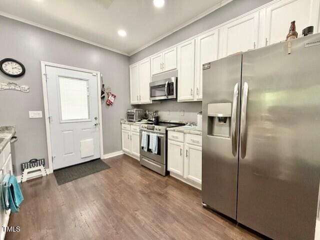 kitchen featuring appliances with stainless steel finishes, crown molding, white cabinetry, light countertops, and dark wood-type flooring