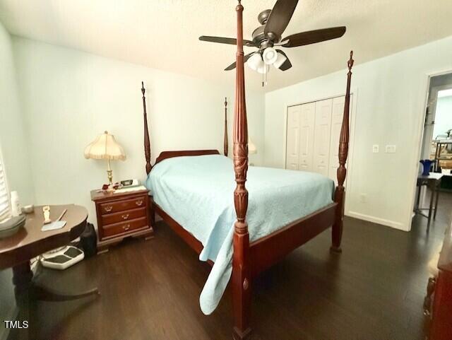 bedroom with wood finished floors, a closet, baseboards, and ceiling fan