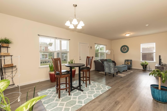 dining area featuring a chandelier, wood finished floors, and baseboards