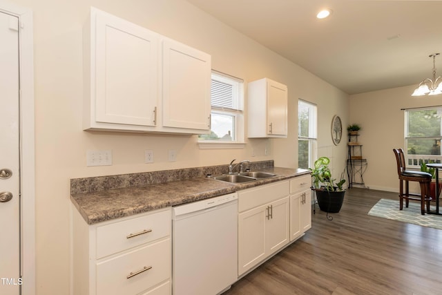 kitchen with dishwasher, a sink, dark wood finished floors, a chandelier, and white cabinetry