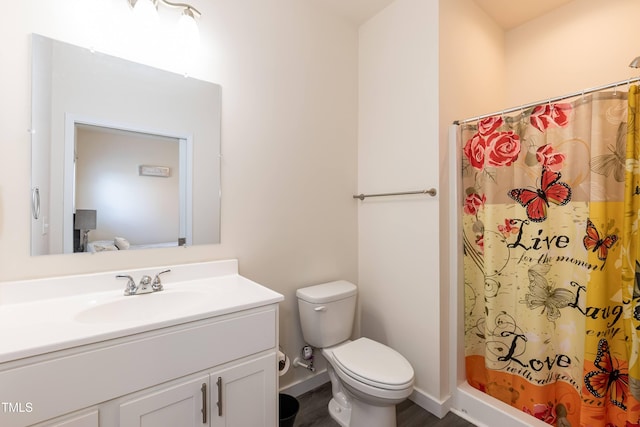 bathroom featuring toilet, curtained shower, and vanity