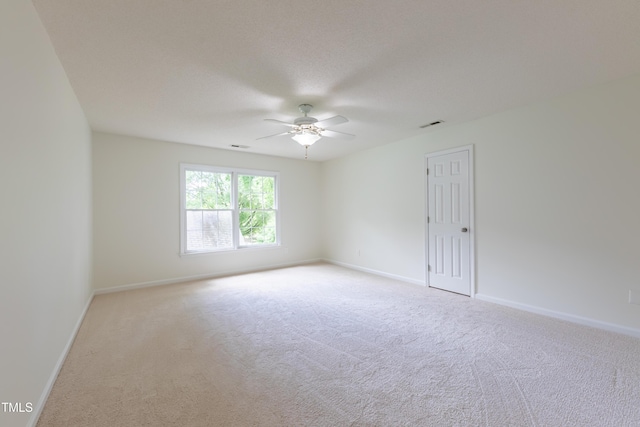 empty room featuring ceiling fan, carpet, and baseboards