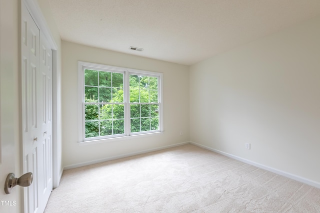 unfurnished bedroom featuring light colored carpet, a closet, and baseboards