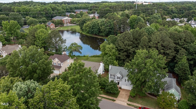 drone / aerial view of a nearby body of water and a forest