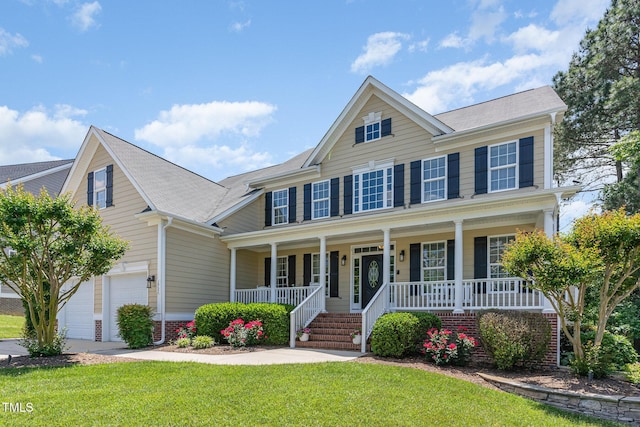 view of front of house featuring covered porch, an attached garage, a front lawn, and roof with shingles